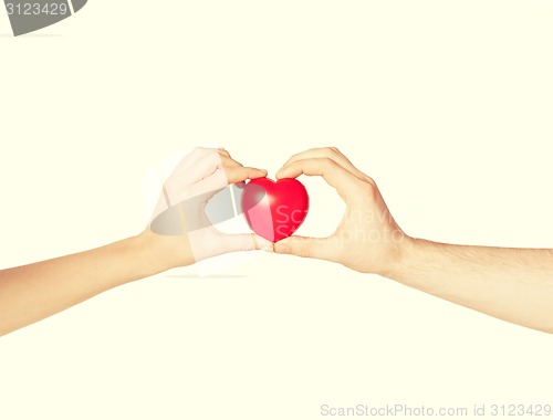 Image of woman and man hands with heart