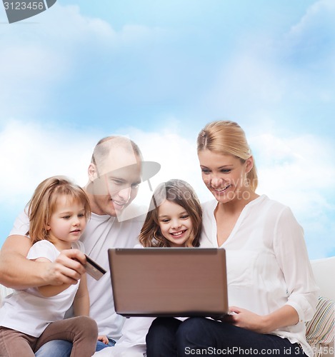 Image of happy family with laptop computer and credit card