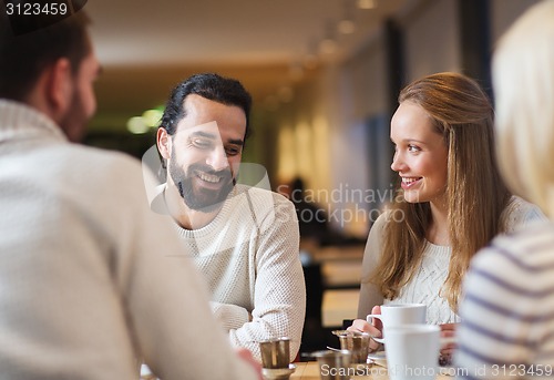Image of happy friends meeting and drinking tea or coffee