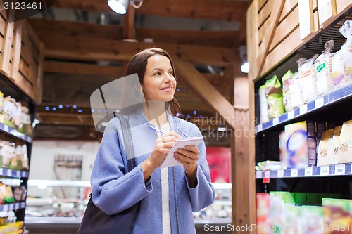 Image of happy woman with notepad in market