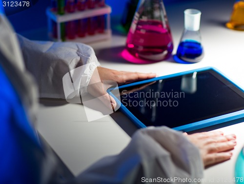 Image of close up of scientist with tablet pc in laboratory