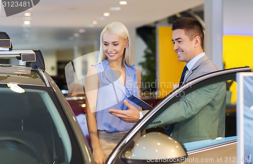 Image of happy woman with car dealer in auto show or salon