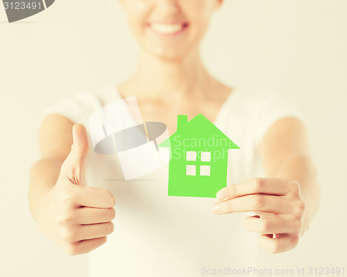 Image of woman hands holding green house