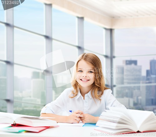 Image of happy girl with books and notebook at school