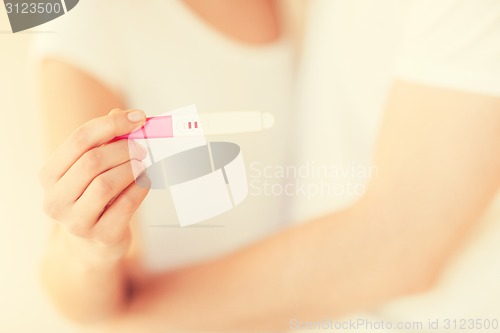 Image of woman and man hands with pregnancy test