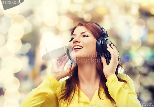 Image of smiling young girl in headphones at home