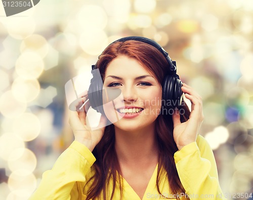 Image of smiling young girl in headphones at home