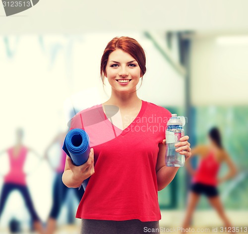 Image of smiling girl with bottle of water after exercising