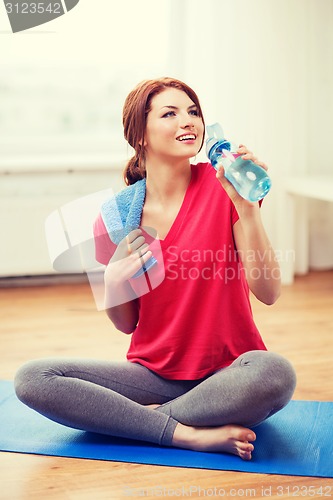 Image of smiling girl with bottle of water after exercising