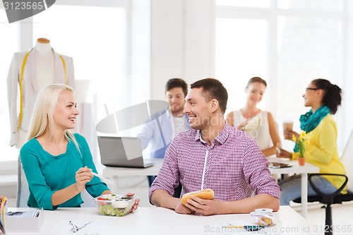 Image of smiling fashion designers having lunch at office