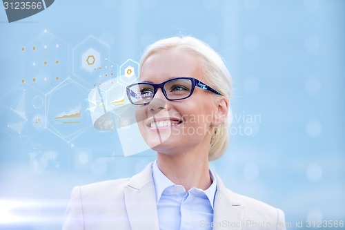 Image of young smiling businesswoman in eyeglasses outdoors