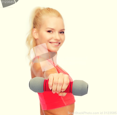 Image of smiling beautiful sporty woman with dumbbell