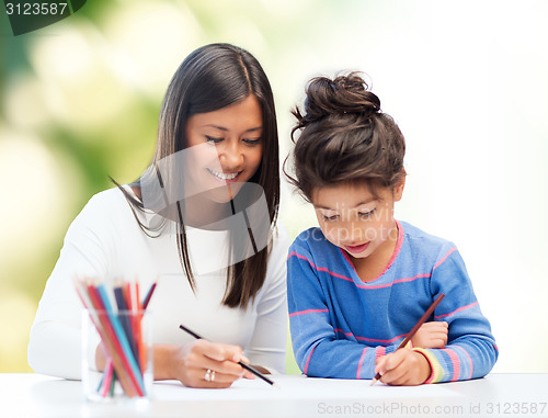 Image of happy mother and daughter drawing with pencils