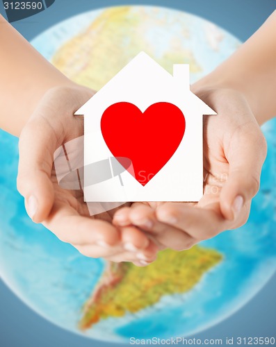 Image of human hands holding paper house with red heart