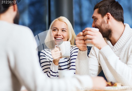 Image of happy friends meeting and drinking tea or coffee