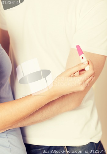 Image of woman and man hands with pregnancy test