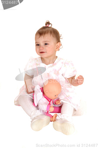 Image of Baby girl playing with dolly.