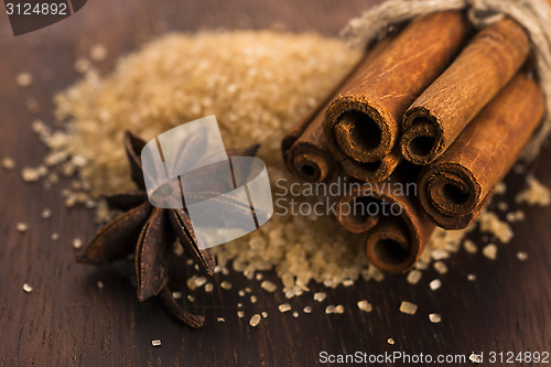 Image of Cinnamon sticks with pure cane brown sugar on wood background