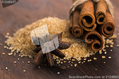 Image of Cinnamon sticks with pure cane brown sugar on wood background