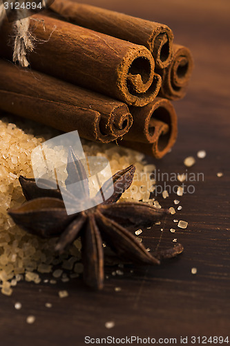 Image of Cinnamon sticks with pure cane brown sugar on wood background