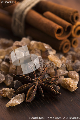 Image of Cinnamon sticks with pure cane brown sugar on wood background