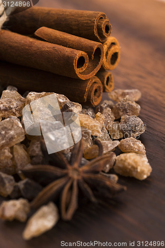 Image of Cinnamon sticks with pure cane brown sugar on wood background