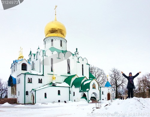 Image of Girl take show fun near Orthodox Theodore's russian church in winter day