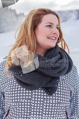 Image of Portrait of a blond chubby woman in winter jacket and thick scarf.
