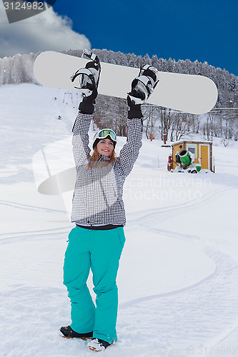 Image of Young chubby woman in winner attitude, raises your snowboard in the air.