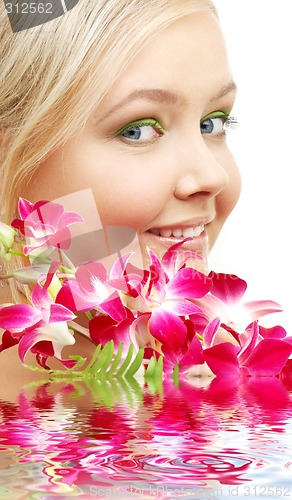 Image of lovely blond with orchid in water