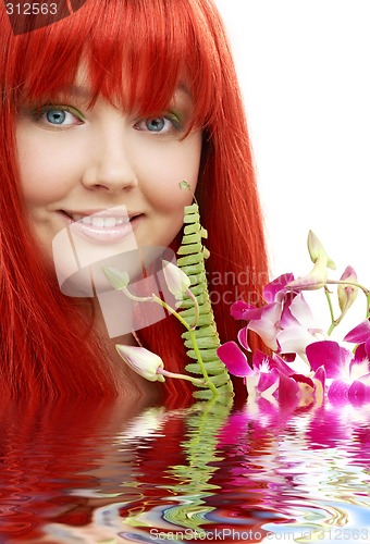 Image of lovely redhead with orchid in water