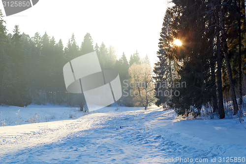 Image of sunrays over fog on river in winter forest