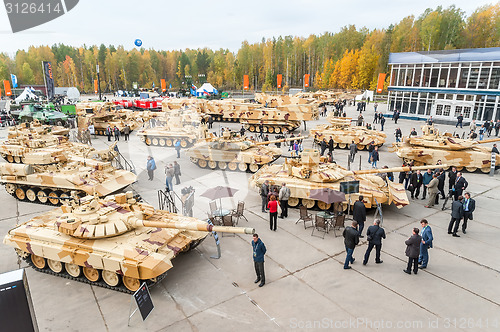 Image of Visitors explore military vehicles on exhibition