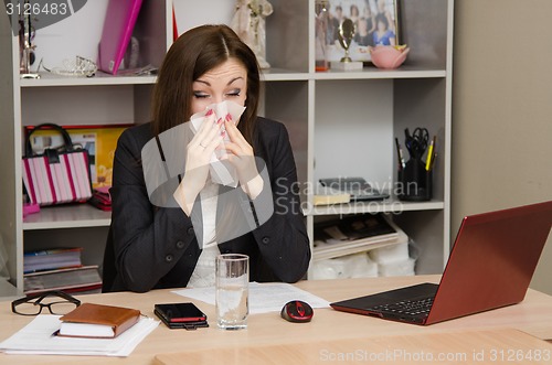 Image of The girl wiping nose with a tissue in the office