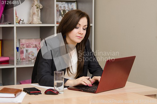 Image of Business woman at the computer prints document