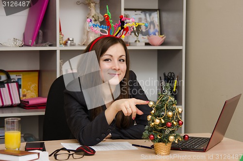 Image of Joyful girl in the office with a Christmas tree