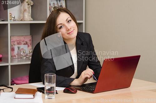Image of Business woman smiling at the computer