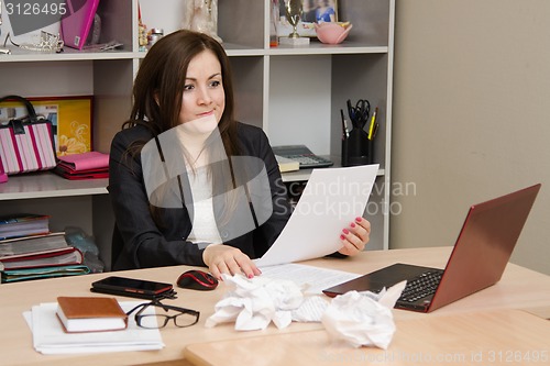 Image of Girl in the office looking at document surprise