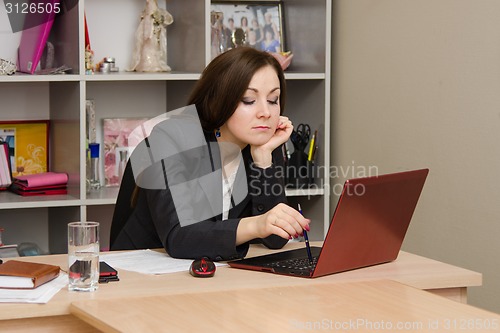 Image of Tired girl at the computer prints document