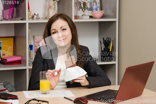 Image of Girl in the office holding a chocolate