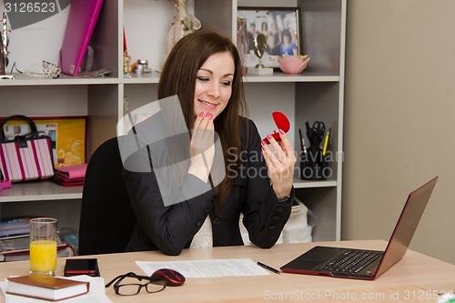 Image of Happy girl in the office looking at jewelry box