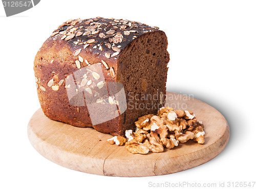 Image of Unleavened bread with seeds on wooden board with nuts