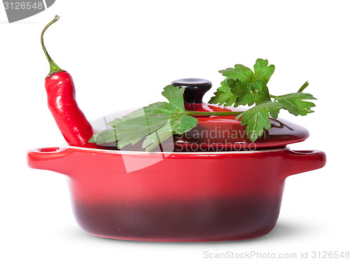 Image of Red pepper in saucepan with lid and parsley on top