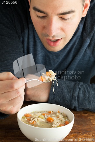 Image of Man Eating Homemade Chicken Soup