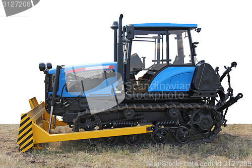 Image of Blue building bulldozer tractor on grass 