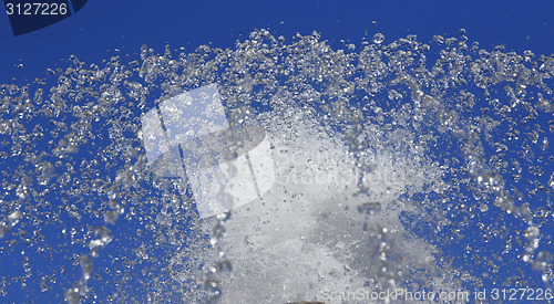 Image of Fountain drops of pure water against a blue sky.