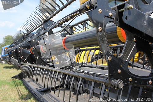 Image of Closeup of harvesting machinery while working the field.