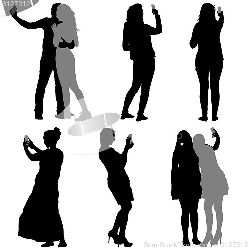 Image of Silhouettes  man and woman taking selfie with smartphone on whit