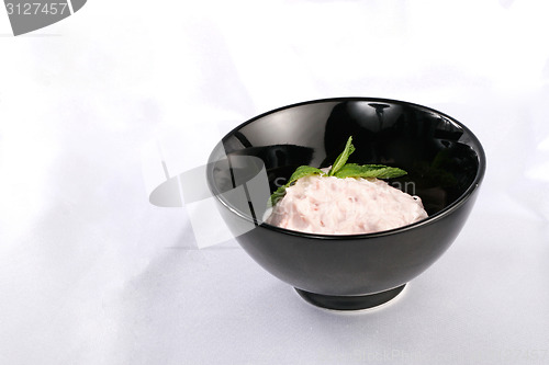 Image of Black plate with cream pink sauce