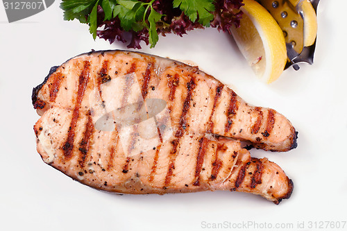 Image of Grilled salmon steak with salad and lemon